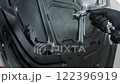 Process of painting a white car in a spray booth. Man using a spray gun 122396919