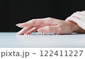 The hands of a person expressing irritation by digging their fingernails into the ground 122411227