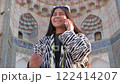 Central Asian charm meets contemporary tech as a uzbek woman in stylish attire engages in a lively smartphone conversation. 122414207