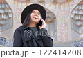 Young female on a call, showcasing fashion and connectivity in a vibrant Asian travel setting. 122414208