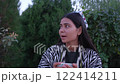 Young uzbek woman in traditional clothing enjoys teatime outdoors 122414211
