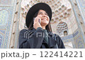Fashion meets function as a stylish woman talks on her phone in a picturesque Asian background. 122414221