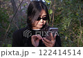 Depressed woman reacting to troubling news on her smartphone, with a distressed expression. Suitable for concepts of bankruptcy, disease, or personal issues, highlighting anxiety and unhappiness 122414514