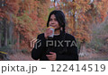 Woman enjoys her coffee, blending modern elegance with a peaceful outdoor vibe. 122414519
