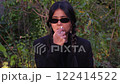 A woman sprays nasal medicine to ease her symptoms, feeling unwell from the freezing air and flu virus. 122414522