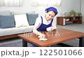 青色のエプロンを付けた白いポロシャツのシニアのハウスキーパー 122501066