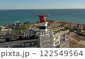 AKTAU, KAZAKHSTAN - FEBRUARY 1, 2025: Overview of coastal buildings and lighthouse against a clear sky and blue sea 122549564