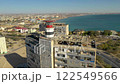 AKTAU, KAZAKHSTAN - FEBRUARY 1, 2025: Aerial view showcasing the coastline and abandoned buildings in a vibrant city landscape 122549566