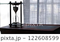 Silhouette view of Hourglass or Sandglass on Old book with Curtain in the background.  122608599