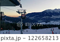 Ski resort with skiers and snowboarders in the evening 122658213