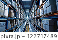 A large industrial warehouse with rows of stacked boxes on shelves and a conveyor belt system, showcasing logistics and storage in a modern facility	 122717489