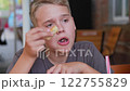 Face of teen boy eating pizza at restaurant, chewing mouth close up, fastfood unhealthy tasty eating. Close-up teenager eating 122755829