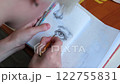 Talented young artist draws in a notebook. Pencil drawing of an eye close-up. 122755831