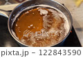 Frying traditional Polish sweet crispy biscuits called Faworki 122843590