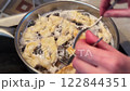 Frying traditional Polish sweet crispy biscuits called Faworki 122844351