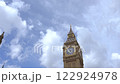 A close up shot of the iconic Big Ben clock tower in London, showing intricate architectural details against a bright blue sky.  122924978