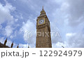 A close up shot of the iconic Big Ben clock tower in London, showing intricate architectural details against a bright blue sky.  122924979