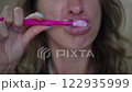 cheerful model brushing mouth at bathroom. Close up happy woman holding toothbrush enjoying morning dental care routine in bath. Portrait fresh lady cleaning teeth having daily procedures at home 122935999
