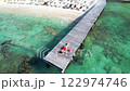 Woman in red swimsuit relaxing on wooden pier above turquoise water in tropical paradise in Cancun Mexico 122974746