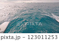 A small boat is gently floating peacefully on top of a large body of water 123011253