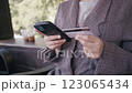 Close up female hands holding credit card and smartphone, shopping online. 123065434