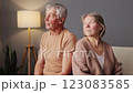 A married couple sits together in a warm living room, reflecting on their shared journey. Their expressions convey contemplation and connection despite a few unspoken feelings 123083585