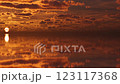 Golden hour magic: A breathtaking sunrise paints the sky with warm hues as clouds race across the horizon.	 123117368