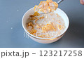 A close-up shot of a spoon lifting a portion of golden cornflakes soaked in fresh milk from a bowl. Perfect for food, health, and lifestyle concepts 123217258