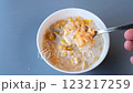 A close-up shot of a spoon lifting a portion of golden cornflakes soaked in fresh milk from a bowl. Perfect for food, health, and lifestyle concepts 123217259