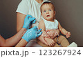 A healthcare professional administers a vaccine to a young child while the mother provides comfort. The setting is child-friendly, ensuring a positive experience during the inoculation 123267924