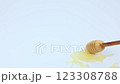 Close-up of a wooden honey spoon smearing liquid yellow honey on a white background. The concept of honey, nectar, dessert. High quality 4k footage 123308788