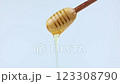 Close-up of a wooden honey spoon on a white background from which liquid yellow honey drips down. The concept of honey, nectar, dessert. High quality 4k footage 123308790