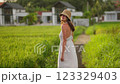 Carefree woman wearing straw hat in the rice field 123329403