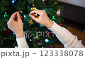 Decorator hangs colorful balls on the Christmas tree 123338078
