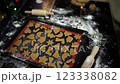 Gingerbread cookies cut out of dough lie on a baking sheet 123338082