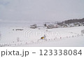 Yellow car drives along a snowy road in a mountain village 123338084