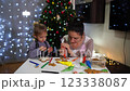 Mom teaches little daughter how to decorate gingerbread with icing 123338087