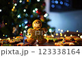 Cookie man in a protective mask stands against the backdrop of a Christmas tree 123338164