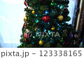Green branches of the Christmas tree decorated with sparkling balls and luminous garlands 123338165