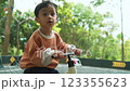 Young Asian Boy Learning to Ride a Bike in the Park on a Sunny Day Young Asian Boy Learning to Ride a Bike in the Park on a Sunny Day 123355623