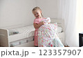 ЗАГРУЗИЛА A girl of 3 years old makes a bed in the children room 123357907