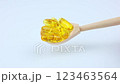 A close-up of fish oil capsules on a white background lies in a wooden spoon, it tilts from side to side. The concept of vitamins, dietary supplements. High quality 4k footage 123463564