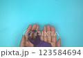 Footage video 4k. Hands holding purple or violet ribbon on blue. Pancreatic Cancer ,Testicular Cancer Awareness, Cancer Survivor, Leiomyosarcoma, World Cancer Day. Healthcare, insurance concept. 123584694