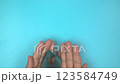 Footage video 4k. Hands holding teal ribbon on blue background.. Ovarian Cancer Awareness, Gynecological, Uterine Cancer, Vulvar Cancer, Panic Disorder, Post Traumatic Stress Disorder (PTSD). 123584749