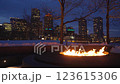 Large outdoor fire pit burning bright on a winter night at Boston Fan Pier Park with the view of the city skyscrapers in the background 123615306
