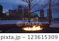 Large outdoor fire pit burning bright on a winter night at Boston Fan Pier Park with the view of the city skyscrapers in the background 123615309