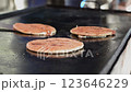 Vendor preparing traditional grilled cheese pupusas. Person hands with spatula flipping artisanal pupusas on the grill. Hands preparing traditional Nicaraguan pupusas 123646229