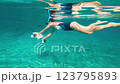 An exhilarating underwater scene displays a swimmer actively utilizing a personal watercraft with joy 123795893