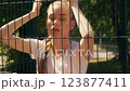 Attractive young woman standing near wire fence, relaxing after street workout 123877411