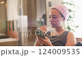 A woman watching a smartphone while brushing her teeth 124009535